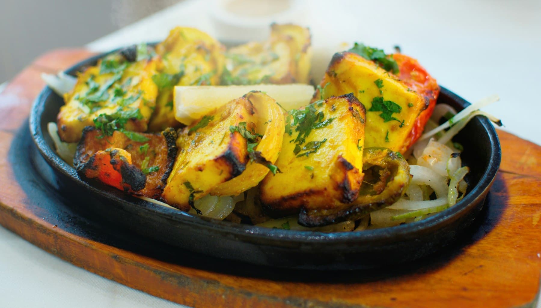 Tikka pieces served sizzling on a hot plate