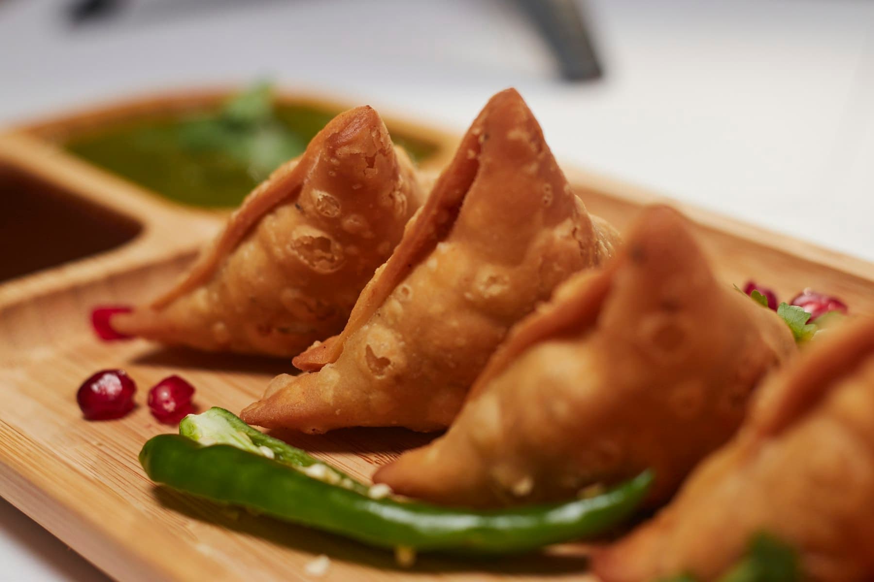 Crisp samosas served with green chutney