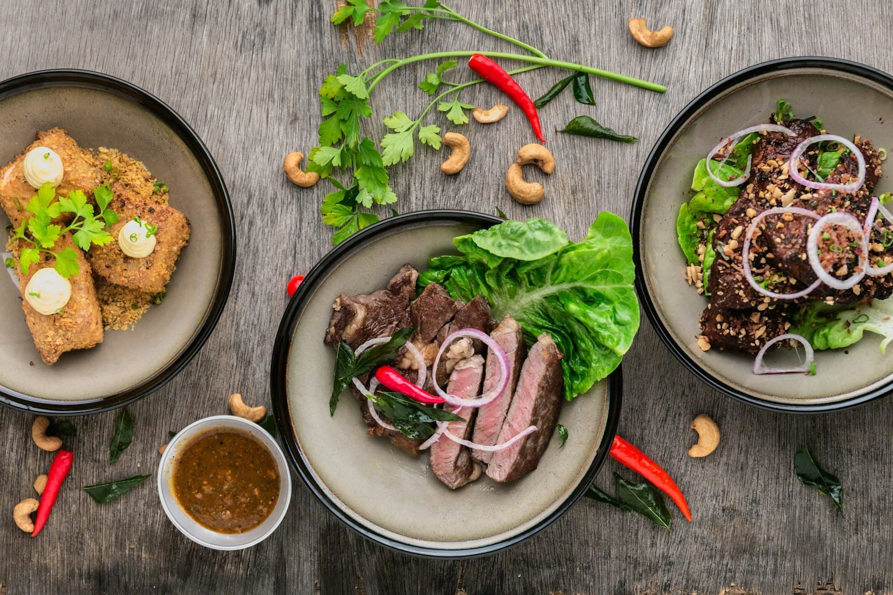 Plated dishes with fresh herbs and chillies on a table